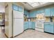 Well-lit kitchen with blue cabinets, white appliances, and efficient layout at 255 Katrina St, De Leon Springs, FL 32130