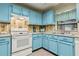Charming kitchen with blue cabinets, stainless steel sink, and modern faucet at 255 Katrina St, De Leon Springs, FL 32130