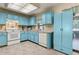 Bright kitchen featuring blue cabinetry, white appliances, and ample counter space at 255 Katrina St, De Leon Springs, FL 32130