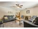 Cozy living room featuring tile floors, ceiling fan, and a comfortable gray leather sofa set at 255 Katrina St, De Leon Springs, FL 32130