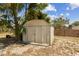 View of the backyard shed with double doors surrounded by trees and greenery at 255 Katrina St, De Leon Springs, FL 32130