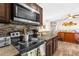 The kitchen has dark cabinetry, an electric stove, and a serving hatch to the dining area at 260 3Rd St, Winter Springs, FL 32708