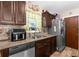 This kitchen features brown cabinetry, a tiled backsplash, and stainless steel appliances at 260 3Rd St, Winter Springs, FL 32708