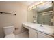 Bathroom featuring a toilet, vanity with sink, large mirror with lighting, and a walk-in shower at 2611 Albion Ave, Orlando, FL 32833