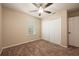 Cozy bedroom with carpet, a ceiling fan, a window with blinds, and a closet at 2611 Albion Ave, Orlando, FL 32833