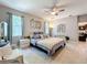 Bright main bedroom showcasing a ceiling fan, seating area, and view to an ensuite bathroom at 2983 Park Meadow Dr, Apopka, FL 32703