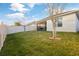 Wide shot of spacious backyard showing screened patio, lawn and white vinyl fence in a private home setting at 3065 Timber Hawk Cir, Ocoee, FL 34761