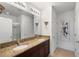 Stylish bathroom with dual sinks, granite countertops, and a large mirror with sconces at 3065 Timber Hawk Cir, Ocoee, FL 34761