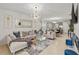 Elegant living room featuring stylish furniture, modern lighting, and open access to the kitchen and dining area at 3065 Timber Hawk Cir, Ocoee, FL 34761