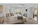 Bright bedroom with a tufted headboard, sitting area, and view to the outdoor patio at 3065 Timber Hawk Cir, Ocoee, FL 34761