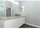 A bright bathroom with light gray walls, a granite countertop, white cabinets, and dark wood-look tile flooring at 3200 Town And Country Rd, Oviedo, FL 32766