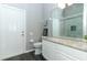 A clean and modern bathroom featuring light gray walls, a toilet, and dark wood-look tile flooring at 3200 Town And Country Rd, Oviedo, FL 32766