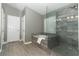 Bathroom showcasing a modern walk-in shower with glass door and tiled surround and a soaking tub at 3200 Town And Country Rd, Oviedo, FL 32766