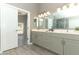 Bathroom featuring double sinks, large mirror, and wood look flooring at 3200 Town And Country Rd, Oviedo, FL 32766