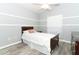 A cozy bedroom featuring gray walls, wood-look floors, a ceiling fan, and a classic dark-wood bed frame at 3200 Town And Country Rd, Oviedo, FL 32766
