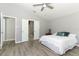 Bedroom featuring a doorway to another room, white trim, ceiling fan and wood look flooring at 3200 Town And Country Rd, Oviedo, FL 32766