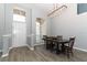 Bright dining room with a modern chandelier, wood floors, and a large window letting in natural light at 3200 Town And Country Rd, Oviedo, FL 32766