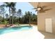 A kidney-shaped pool and spillover spa are surrounded by palm trees and a beautiful landscape at 3200 Town And Country Rd, Oviedo, FL 32766