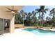 Relaxing pool and spa combo surrounded by palms and mature trees in the fenced yard at 3200 Town And Country Rd, Oviedo, FL 32766