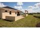 View of the backyard with green lawn, and brick-paved patio with an outdoor kitchen at 3285 Songbird Cir, Harmony, FL 34773