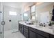 Bright bathroom features double vanity sinks, a glass shower and white marble-style tile at 3285 Songbird Cir, Harmony, FL 34773