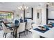 Bright dining area with stylish decor, modern lighting, and a view of the living area and kitchen at 3285 Songbird Cir, Harmony, FL 34773