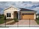 Inviting single-Gathering home with a brick driveway, a two-car garage, and a well-manicured lawn at 3285 Songbird Cir, Harmony, FL 34773