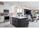 Modern kitchen with stainless steel appliances, a large island, and views of the living and dining areas at 3285 Songbird Cir, Harmony, FL 34773