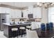 Bright kitchen and dining area with white cabinets, a spacious island, and modern pendant lighting at 3285 Songbird Cir, Harmony, FL 34773