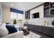 Cozy living room with custom shelving, comfortable seating, and a large window showcasing outdoor views at 3285 Songbird Cir, Harmony, FL 34773