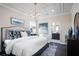 Comfortable primary bedroom with decorative tray ceiling, chandelier, and ensuite bathroom at 3285 Songbird Cir, Harmony, FL 34773