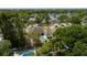 A beautiful home showcases a private pool, manicured lawn, and stunning views of the surrounding lake and lush greenery at 3535 Lake Sarah Dr, Orlando, FL 32804