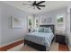 Bedroom with a queen bed, two windows with shutters, and wood floors on top of a neutral rug at 3535 Lake Sarah Dr, Orlando, FL 32804
