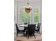 Bright dining area featuring a round table, four chairs, and a stylish chandelier near shuttered windows at 3535 Lake Sarah Dr, Orlando, FL 32804