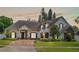 Stunning front exterior of a luxury home with meticulous landscaping, stone accents, and a paved driveway at 3535 Lake Sarah Dr, Orlando, FL 32804