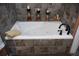 Tile-surround bathtub with jacuzzi jets and black fixtures at 36019 Clear Lake Dr, Eustis, FL 32736