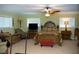 A bedroom with a ceiling fan, windows, furniture, a television, and a bed with an ornate headboard at 36019 Clear Lake Dr, Eustis, FL 32736