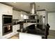 Modern kitchen featuring white cabinetry, stainless steel appliances, and a dark granite countertop island with pendant lighting at 36019 Clear Lake Dr, Eustis, FL 32736