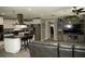 Modern kitchen with stainless appliances, white cabinetry, island seating, and an open living area at 36019 Clear Lake Dr, Eustis, FL 32736