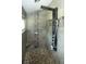 Modern shower with custom tile work, multiple shower heads, a built-in seat, and river rock flooring at 36019 Clear Lake Dr, Eustis, FL 32736