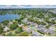 Aerial view of a suburban neighborhood featuring a lake, lush trees, and homes with swimming pools at 3713 Dover St, Orlando, FL 32806
