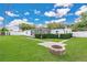Spacious backyard with lush green grass, complemented by a charming fire pit and a well-manicured hedge at 3713 Dover St, Orlando, FL 32806