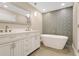 Bright bathroom with a soaking tub, double vanity, and stylish tile accent wall at 3713 Dover St, Orlando, FL 32806