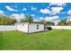 Side view of a well-maintained home with green lawn, white fence, and blue skies at 3713 Dover St, Orlando, FL 32806
