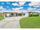 Inviting home featuring a well-manicured lawn, covered carport, and a beautifully designed driveway at 3713 Dover St, Orlando, FL 32806