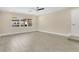 Well-lit living room with a large window, neutral walls, and modern tiled floors at 3713 Dover St, Orlando, FL 32806