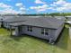 Aerial view of the backyard and home showing the patio, dark roof, lush green grass, and fence at 439 Sarah Nicole Way, New Smyrna Beach, FL 32168