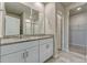 Modern bathroom with double sinks, granite countertop, and a walk-in shower at 439 Sarah Nicole Way, New Smyrna Beach, FL 32168