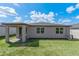 Back exterior view of the home showcasing a patio, windows, lush green yard, and AC Unit at 439 Sarah Nicole Way, New Smyrna Beach, FL 32168