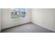 Bedroom with neutral carpeting, trim and a view of the neighborhood through the window at 4497 Yaupon Holly Way, Lakeland, FL 33811